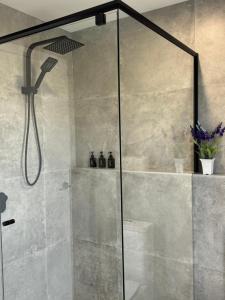 a shower in a bathroom with a glass door at Light Blue in Tullimbar