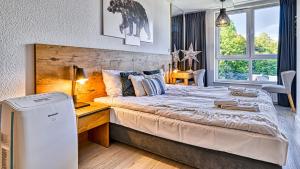 a bedroom with a large bed with a desk and a window at Apartament Kozubnik SPA 47 Spacer w Chmurach blisko Szczyrk - 5D Apartamenty in Porąbka