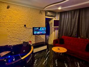 a living room with a red couch and a tv at Bakırköy Macro Suite Otel in Istanbul