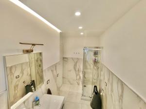 a white bathroom with a shower and a sink at Venezia Home in Rovereto