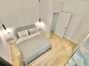 a small white room with a bed and a door at Venezia Home in Rovereto +1 photo