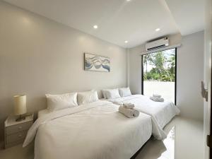 a bedroom with two beds and a window at Pisingha Pool Villa Khanom in Khanom +140 photos