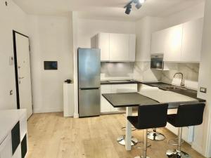 a kitchen with a table and a stainless steel refrigerator at Venezia Home in Rovereto
