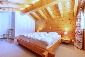 een slaapkamer met een bed in een houten kamer bij Meinaz W 030 - QUIET apartment 7 pers in Veysonnaz