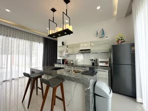 a kitchen with a counter and a refrigerator at Pisingha Pool Villa Khanom in Khanom