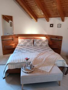 Un dormitorio con una cama grande con cabecero de madera. en Casa Sally, en San Michele allʼAdige