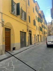 a yellow building with a car parked on a street at MagicFlo Santa Croce Appartamento in Florence