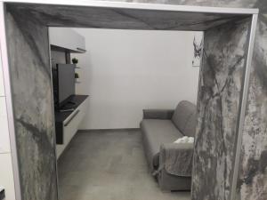 Una sala de estar con un sofá y un televisor. en Casa Bijou, en Marsala