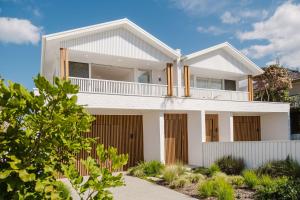 Una casa blanca con un balcón encima. en Betty at Mollymook, en Mollymook