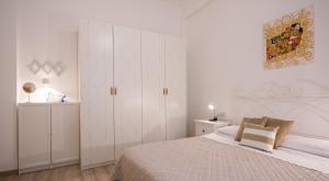 a white bedroom with a bed and a white cabinet at Frog 30 in Gabicce Mare