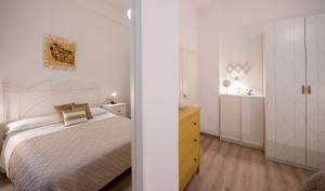 a white bedroom with a bed and a yellow dresser at Frog 30 in Gabicce Mare +13 photos