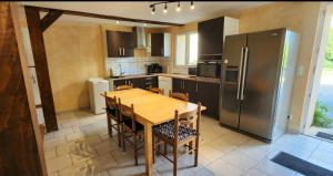 a kitchen with a wooden table and a refrigerator at LOCATIONS RIVES DE SEUGNE - Claveau in Jonzac