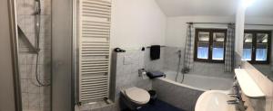 a bathroom with a tub and a toilet and a sink at Ferienwohnungen Gruber in Kiefersfelden