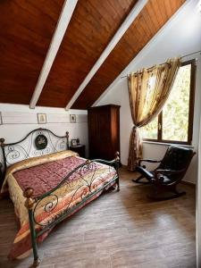 a bedroom with a bed and a chair and a window at Cabana La Gog in Raşca