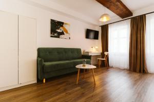 a living room with a green couch and a table at Townhouse Boutique in Sibiu