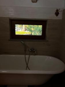 a bath tub in a bathroom with a window at Cabana La Gog in Raşca +22 photos