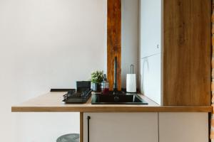 a kitchen with a sink and a wooden cabinet at Townhouse Boutique in Sibiu +81 photos