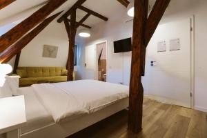 a bedroom with a white bed and a yellow couch at Townhouse Boutique in Sibiu