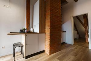 a brick wall in a kitchen with a stool at Townhouse Boutique in Sibiu