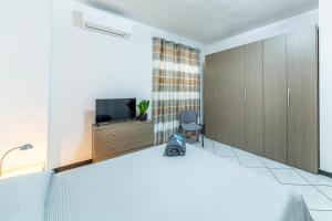 a bedroom with a bed and a tv and a chair at Bed Room da Zio Tore in Ottana +19 photos