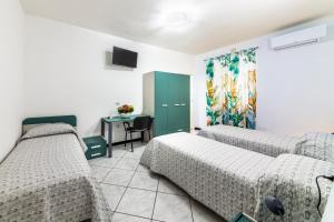 a room with two beds and a table with a desk at Bed Room da Zio Tore in Ottana