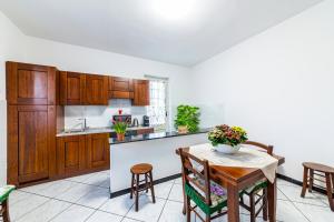 a kitchen with wooden cabinets and a table and chairs at Bed Room da Zio Tore in Ottana