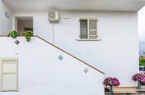 a white building with some plants on the stairs at Bed Room da Zio Tore in Ottana