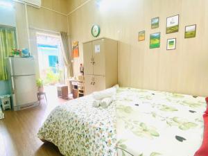 Un dormitorio con una cama con una colcha floral. en Cozy Homestay with Large bed, private bathroom, large Balcony, en Hanói