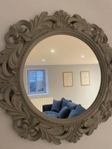 a mirror with a blue couch in a living room at Appartement plein centre, garage recharge voiture in Langres