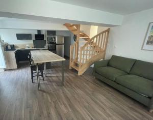 a living room with a couch and a table and a kitchen at Maison de ville- quartier calme in Vitré