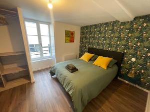 a bedroom with a bed with a floral wall at Maison de ville- quartier calme in Vitré
