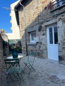a table and chairs sitting in front of a building at Maison de ville- quartier calme in Vitré