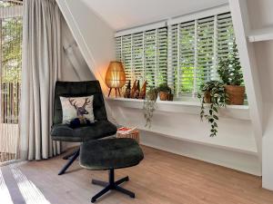 a black chair sitting in a room with a window at Boszicht Durbuy in Durbuy