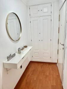 ein Badezimmer mit Waschbecken und Spiegel in der Unterkunft 10 minutos centro Sevilla, moderno y con parking gratis in Sevilla