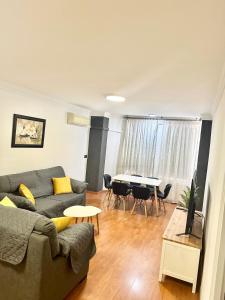 ein Wohnzimmer mit Sofa und Tisch in der Unterkunft 10 minutos centro Sevilla, moderno y con parking gratis in Sevilla + 37 Fotos