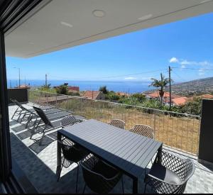 a table and chairs on a balcony with a view of the ocean at The Vibe Madeira Apartment 2 in Arco da Calheta