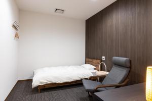 a bedroom with a bed and a desk and a chair at Kiso Mikawaya in Kiso
