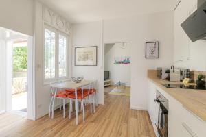 a kitchen with a table and chairs in a room at Maison avec terrasse proche Lyon in Rillieux