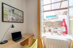 a room with a desk and a window with a laptop at Maison avec terrasse proche Lyon in Rillieux