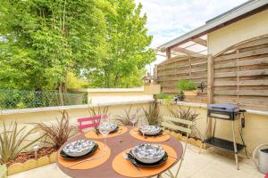a table with plates of food on a patio at Maison avec terrasse proche Lyon in Rillieux