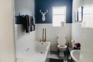 a bathroom with a tub and a toilet and a sink at Klein Geluk Cottage in Nieu-Bethesda +24 photos
