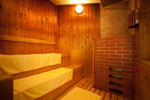 a sauna with two beds and a brick wall at Kijima Kogen Hotel in Beppu