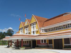 un edificio giallo e rosso con tetto rosso di Hoang Thang 1 Hotel Da Lat City a Da Lat