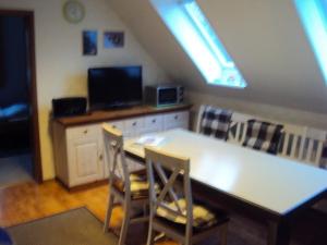 a kitchen with a table with two chairs and a television at Ferienwohnung Jork Altes Land bei Hamburg an der Elbe in Jork
