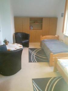 a bedroom with a bed and a chair and a table at Ferienwohnung Jork Altes Land bei Hamburg an der Elbe in Jork +13 photos