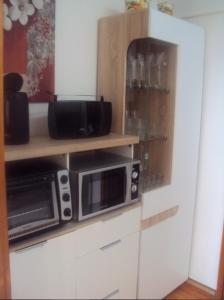 a kitchen with a microwave on a shelf and a counter at Ferienwohnung Jork Altes Land bei Hamburg an der Elbe in Jork