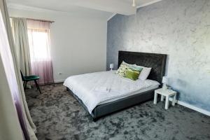 a bedroom with a large bed with green pillows at Casa Korman in Giarmata +55 photos