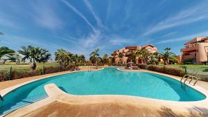 a swimming pool in a resort with palm trees and buildings at Casa PedroRoca VA-Murcia Holiday Rentals Property in Torre-Pacheco