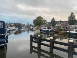 a river with boats docked in a city at Logement Sylroede in Lemmer