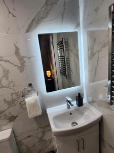 a white bathroom with a sink and a mirror at Dublin Deluxe Twin or king bed Studio Near Airport & City in Dublin